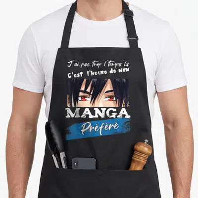Tablier de cuisine noir avec un personnage de manga aux yeux rouges et une phrase humoristique en typographie blanche et bleue.