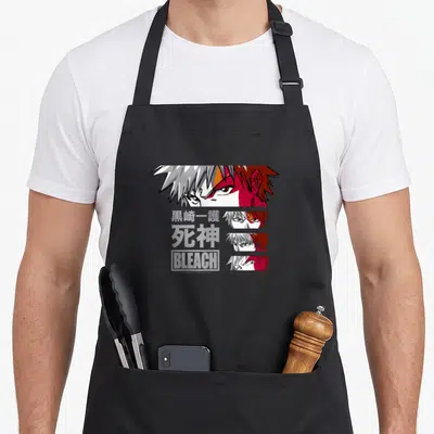 Tablier de cuisine noir avec une illustration d'Ichigo Kurosaki en esquisse fragmentée et des caractères japonais gris.