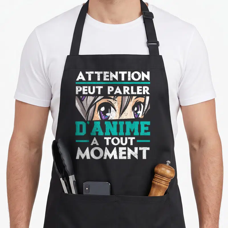 Tablier de cuisine noir avec illustration d'yeux anime et texte blanc et turquoise.