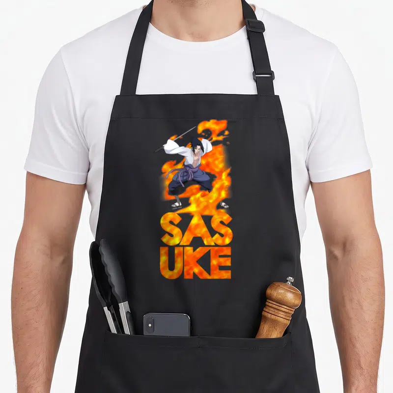 Tablier de cuisine noir avec Sasuke et des flammes orange formant le mot SASUKE