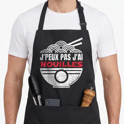 Tablier de cuisine noir avec illustration d'un bol de nouilles et texte humoristique en blanc et rouge.