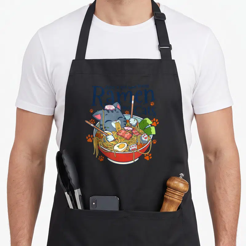 Tablier de cuisine noir avec illustration d'un chat mangeant du ramen et le texte Just a girl who loves Ramen and Cats.