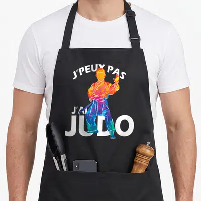 Tablier de cuisine noir avec illustration colorée d'un judoka et texte blanc J'peux pas j'ai judo