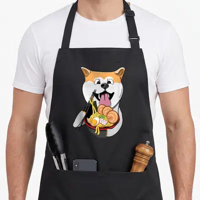 Tablier de cuisine noir avec illustration d'un chien Akita Inu mangeant du ramen avec des baguettes.
