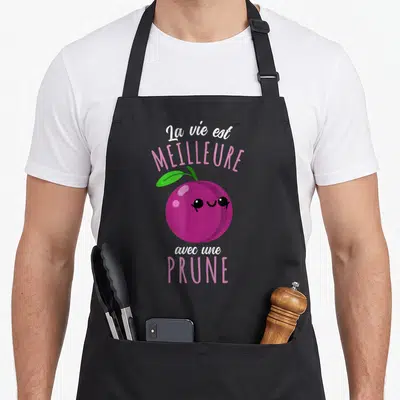 Tablier de cuisine noir avec une prune kawaii rose et le texte La vie est meilleure avec une prune