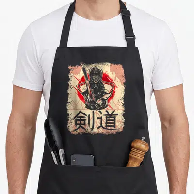 Tablier de cuisine noir avec illustration d'un kendoïka tenant un shinai devant des kanjis.