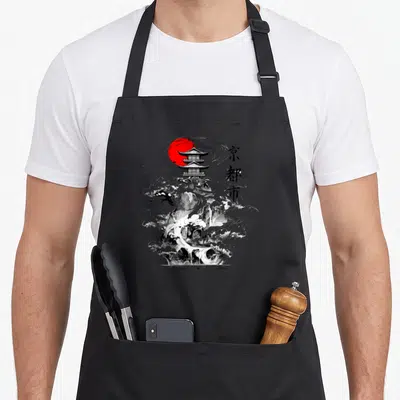 Tablier de cuisine noir avec illustration château japonais, soleil rouge et characters calligraphiés.