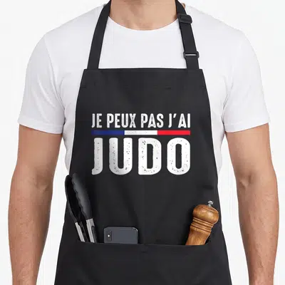 Tablier de cuisine noir avec le texte Je peux pas j'ai judo et un drapeau tricolore.