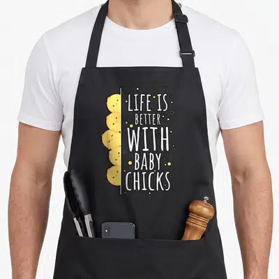 Tablier de cuisine noir avec cinq poussins jaunes kawaii et le texte Life is better with baby chicks en blanc.
