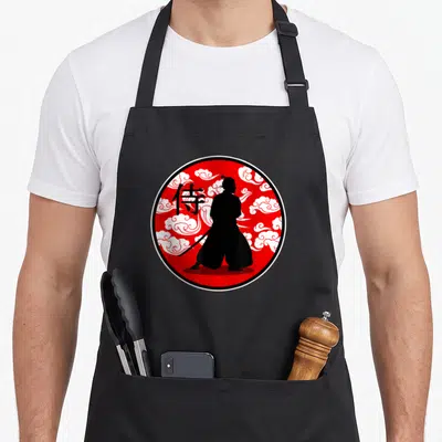 Tablier de cuisine noir avec un motif circulaire rouge représentant un samouraï et des nuages blancs stylisés.