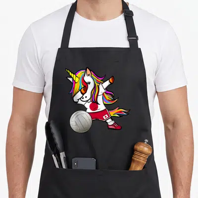 Tablier de cuisine noir avec une licorne colorée en train de faire un dab avec un ballon de volley-ball et des motifs japonais.
