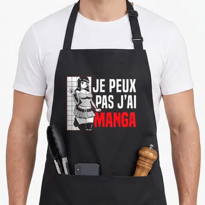 Tablier de cuisine noir avec une illustration de fille manga et le texte Je peux pas j'ai manga en blanc et rouge.