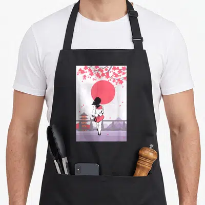 Tablier de cuisine noir avec illustration d'une fille dos tourné devant un soleil rouge et des fleurs de sakura roses.