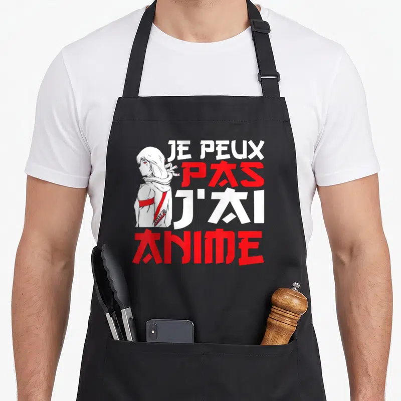 Tablier de cuisine noir avec une illustration de fille aux cheveux blancs et le texte Je peux pas j'ai anime en blanc et rouge.