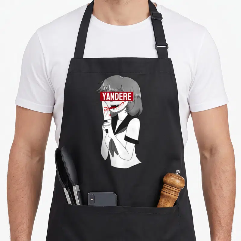 Tablier de cuisine noir avec illustration d'une fille anime au couteau et le mot YANDERE en rouge sur les yeux.