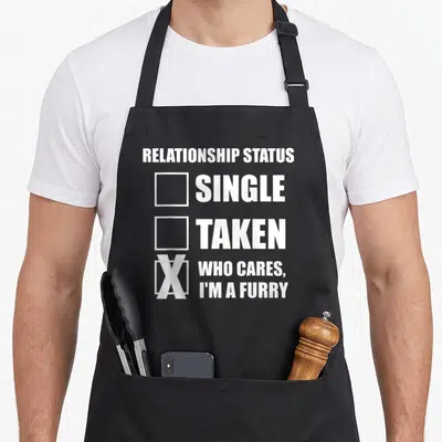 Tablier de cuisine noir avec inscription blanche Relationship Status Who Cares I'm A Furry sur le devant.