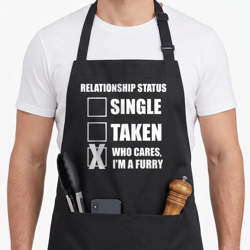 Tablier de cuisine noir avec inscription blanche Relationship Status Who Cares I'm A Furry sur le devant.
