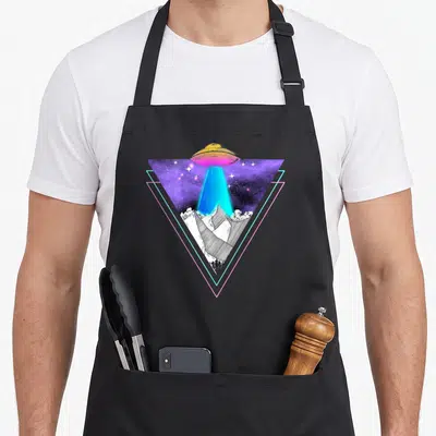 Tablier de cuisine noir avec illustration d'un UFO vaporwave au-dessus de montagnes en noir et blanc dans un triangle géométrique.