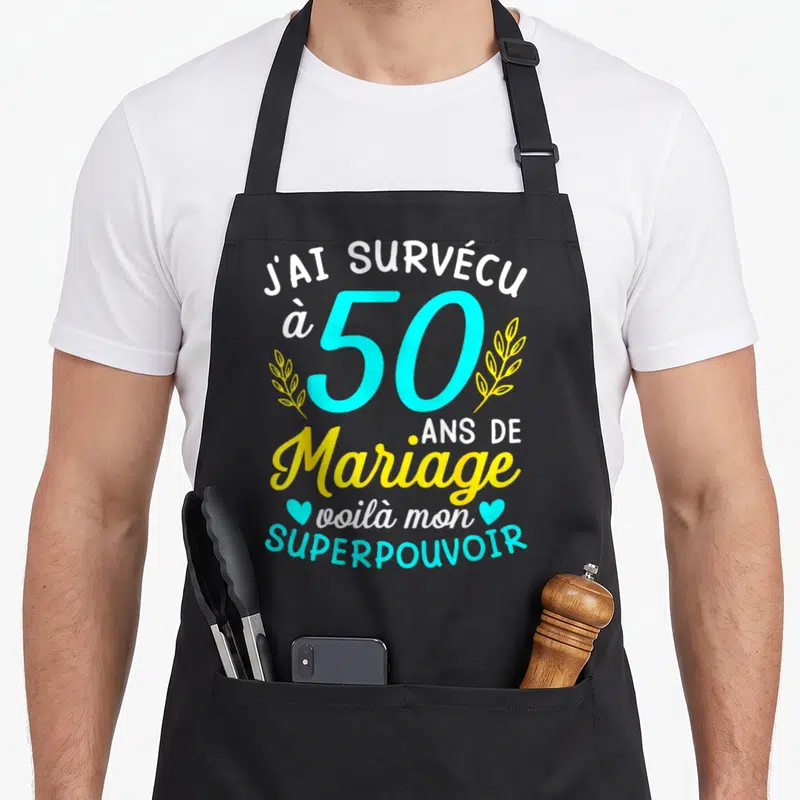 Tablier de cuisine noir avec inscription J'ai survécu à 50 ans de mariage et superpouvoir en bleu cyan et jaune.