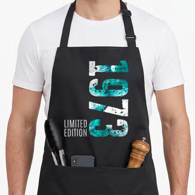 Tablier de cuisine noir avec le chiffre 1973 en texture turquoise et l'inscription Limited Edition en blanc.