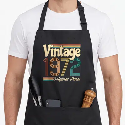 Tablier de cuisine noir avec le motif vintage 1972 original parts en lettres colorées retro