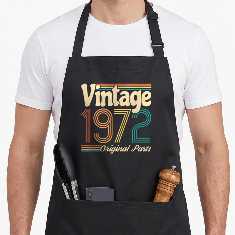 Tablier de cuisine noir avec le motif vintage 1972 original parts en lettres colorées retro