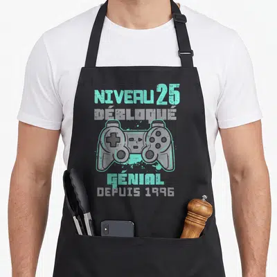 Tablier de cuisine noir avec manette de jeu vidéo et texte Niveau 25 Débloqué Génial depuis 1996 en turquoise et gris.