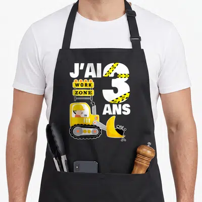 Tablier de cuisine noir avec illustration pelleteuse jaune, chiffre 3 et panneau Work Zone.