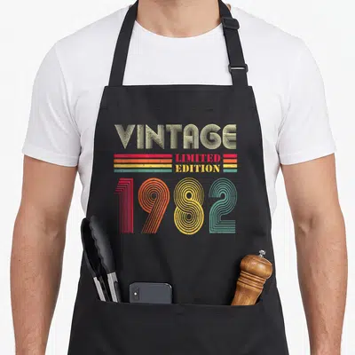 Tablier de cuisine noir avec typographie vintage 1982 Limited Edition multicolore.