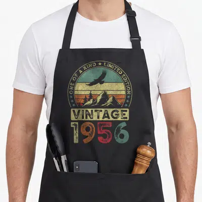 Tablier de cuisine noir avec motif vintage 1956 « édition limitée » 70 ans illustrant un paysage montagneux et un aigle en vol.