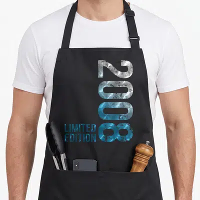 Tablier de cuisine noir avec l'inscription 2008 Limited Edition en lettres métalliques bleues et argentées style vintage.
