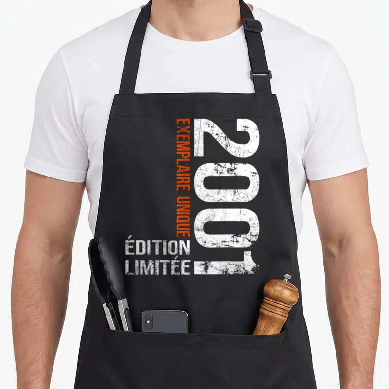 Tablier de cuisine noir avec l'année 2001 en blanc et le texte Exemplaire Unique en orange vertical.