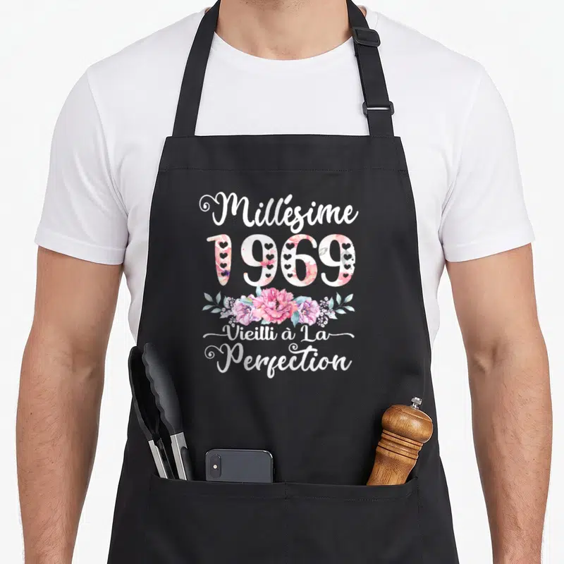 Tablier de cuisine noir avec texte blanc millésime 1969 vieilli à la perfection et bouquet floral rose