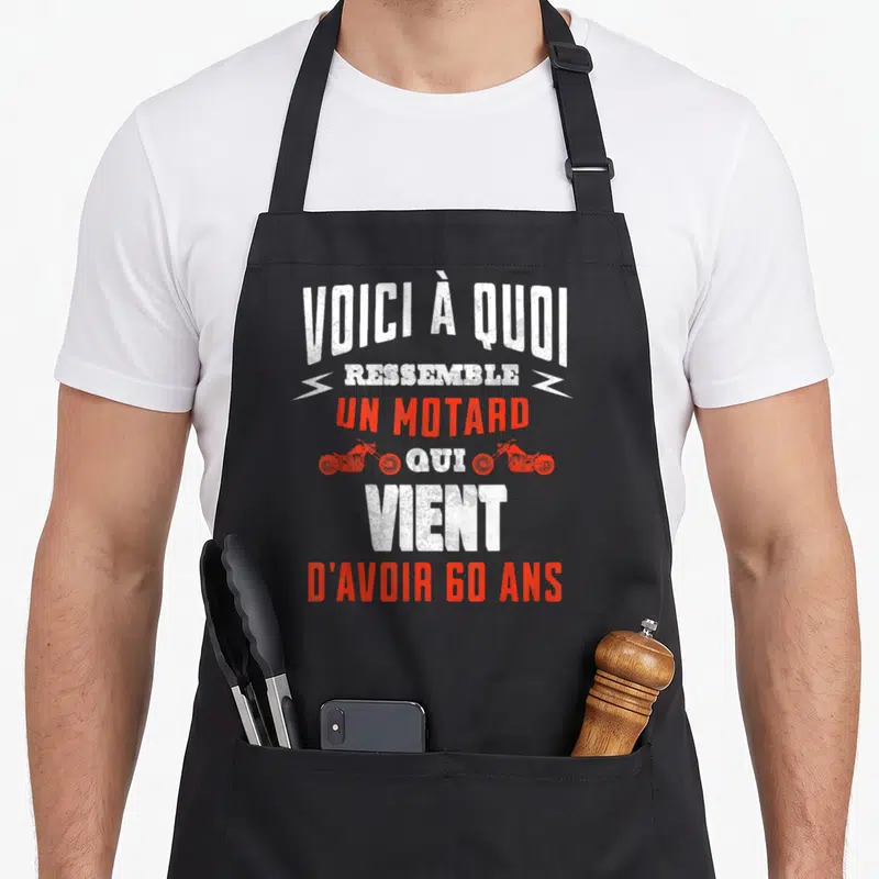 Tablier de cuisine noir avec inscription voici à quoi ressemble un motard qui vient d'avoir 60 ans en blanc et rouge.