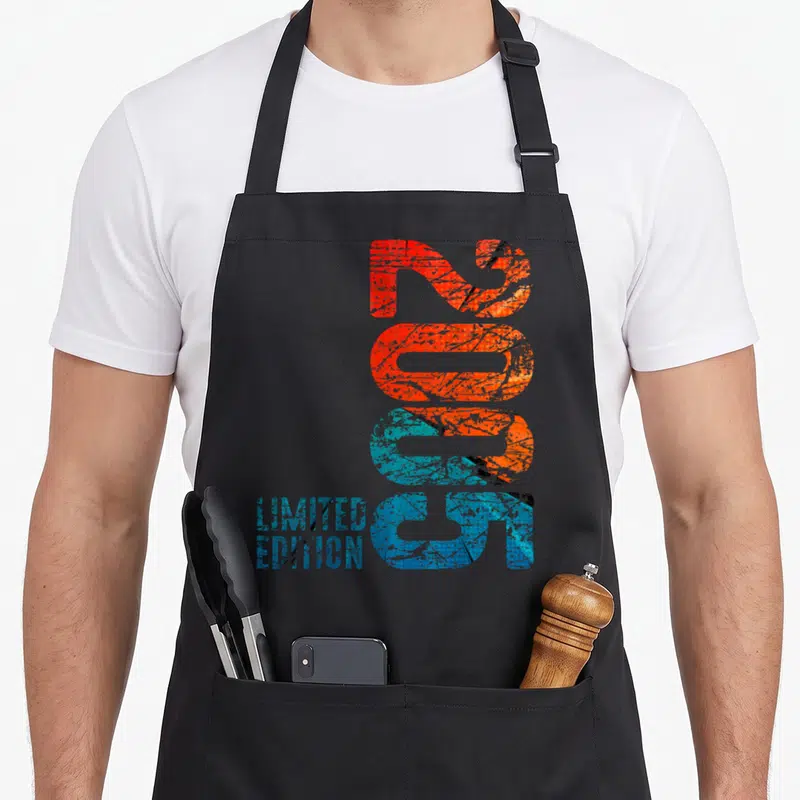 Tablier de cuisine noir avec l'année 2005 en grandes lettres verticales orange et bleues ainsi que le texte Limited Edition en bas à gauche.
