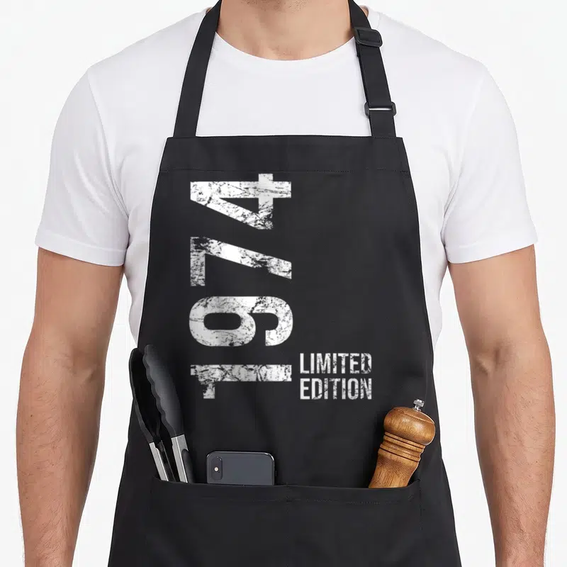 Tablier de cuisine noir avec le chiffre 1974 vertical et Limited Edition en blanc sur fond uni.