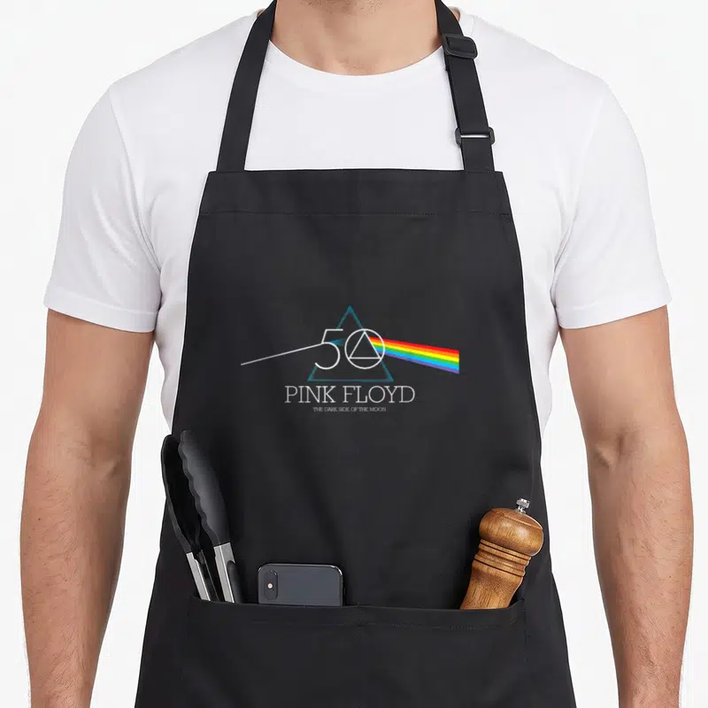 Tablier de cuisine noir avec le logo du 50e anniversaire de Pink Floyd et un prisme émettant un arc-en-ciel.