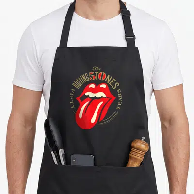Tablier de cuisine noir avec la langue rouge des Rolling Stones et l'inscription 50 ans en doré.
