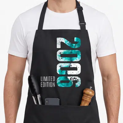 Tablier de cuisine noir avec grand chiffre 2006 rempli de motifs marins turquoise et blanc, Limited Edition en bas à gauche.