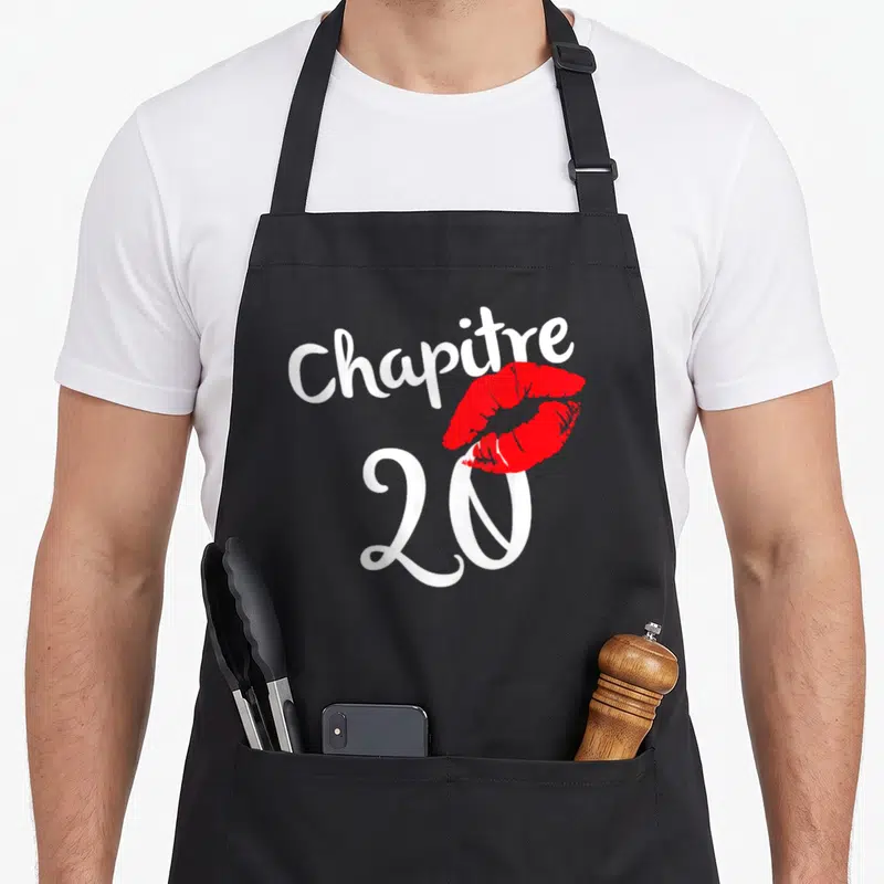 Tablier de cuisine noir avec inscription Chapitre 20 ans et empreinte de lèvres rouges au centre du design.