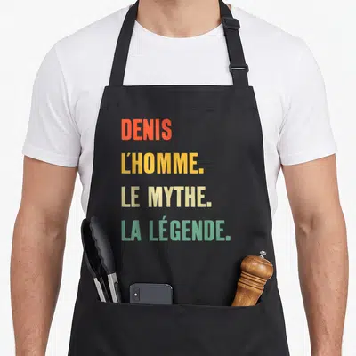 Tablier de cuisine noir avec inscription colorée Denis l'homme le mythe la légende en typographie moderne.