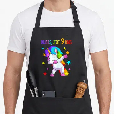 Tablier de cuisine noir avec licone multicolore en train de faire le dab et des étoiles.