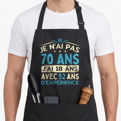 Tablier de cuisine noir avec inscription humoristique 70 ans et typographie vintage bleue et crème.