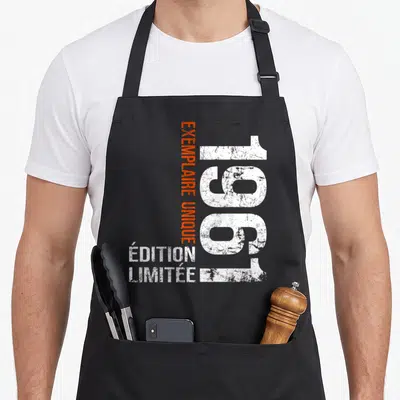 Tablier de cuisine noir avec l'année 1961 en blanc et texte exemplaire unique en orange vertical.