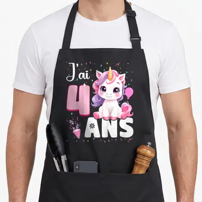 Tablier de cuisine noir avec une licorne rose, le chiffre 4 et des confettis colorés imprimés sur le devant.