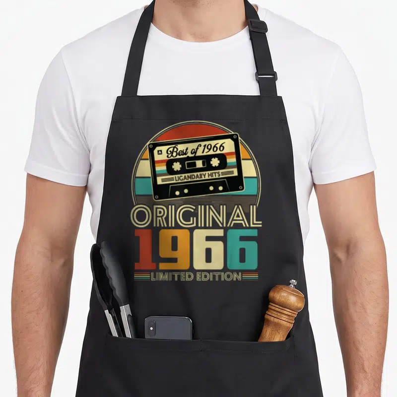Tablier de cuisine noir avec illustration vintage cassette Best of 1966 Limited Edition et texte coloré.