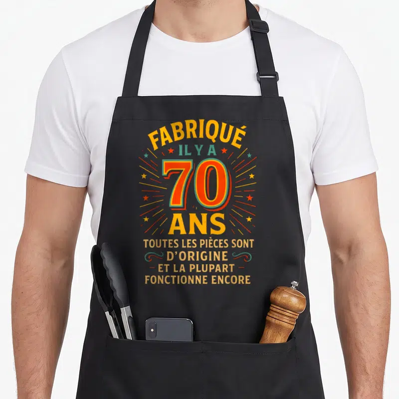 Tablier de cuisine noir avec inscription fabrique il y a 70 ans en typographie colorée vintage.