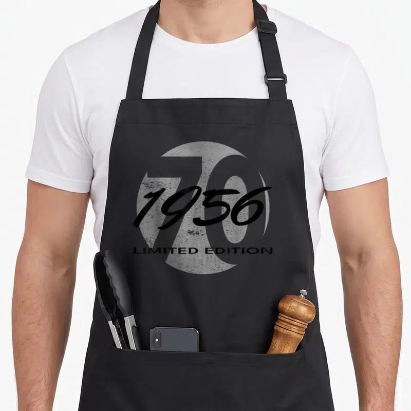 Tablier de cuisine noir avec l'année 1956 en écriture cursive et Limited Edition en dessous.