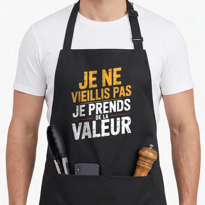 Tablier de cuisine noir avec inscription jaune et blanche Je ne vieillis pas je prends de la valeur.