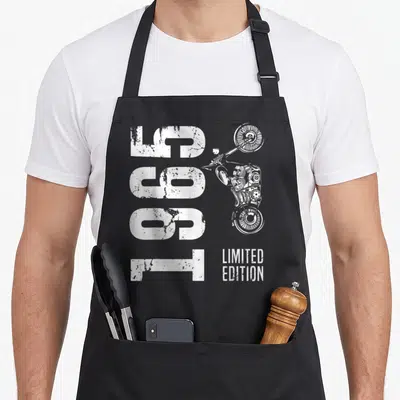Tablier de cuisine noir avec illustration vintage moto et texte limited edition en blanc sur fond uni.
